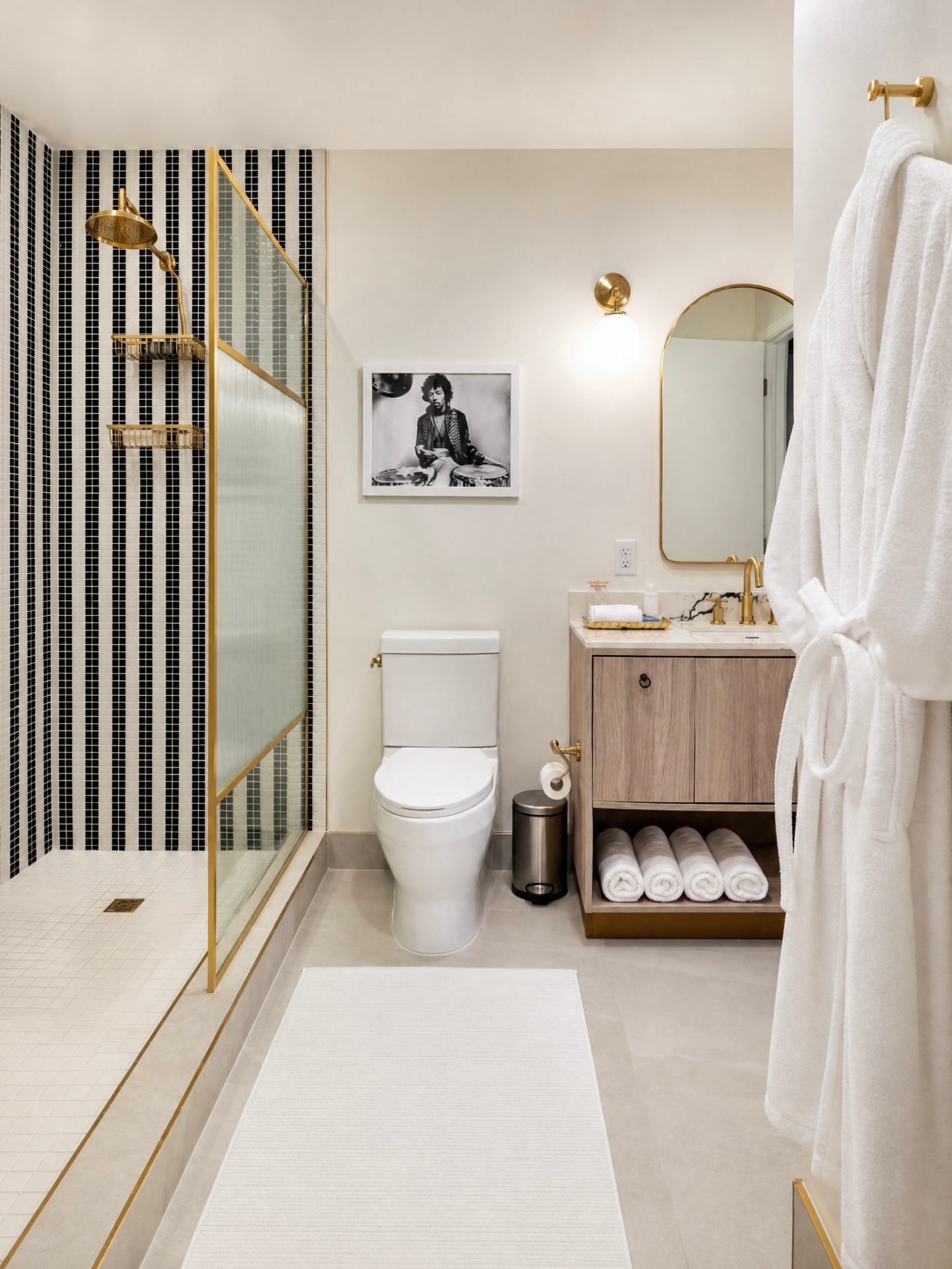 Walk-in shower with black-and-white mosaic tile and brass fixtures