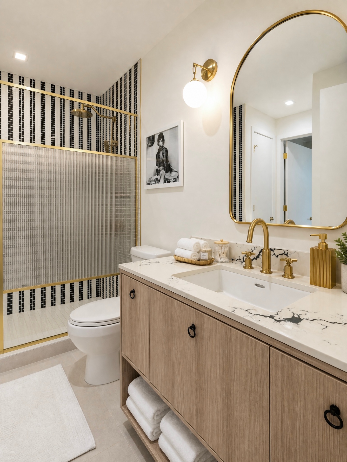 Bathroom vanity with arched brass mirror and marble counter