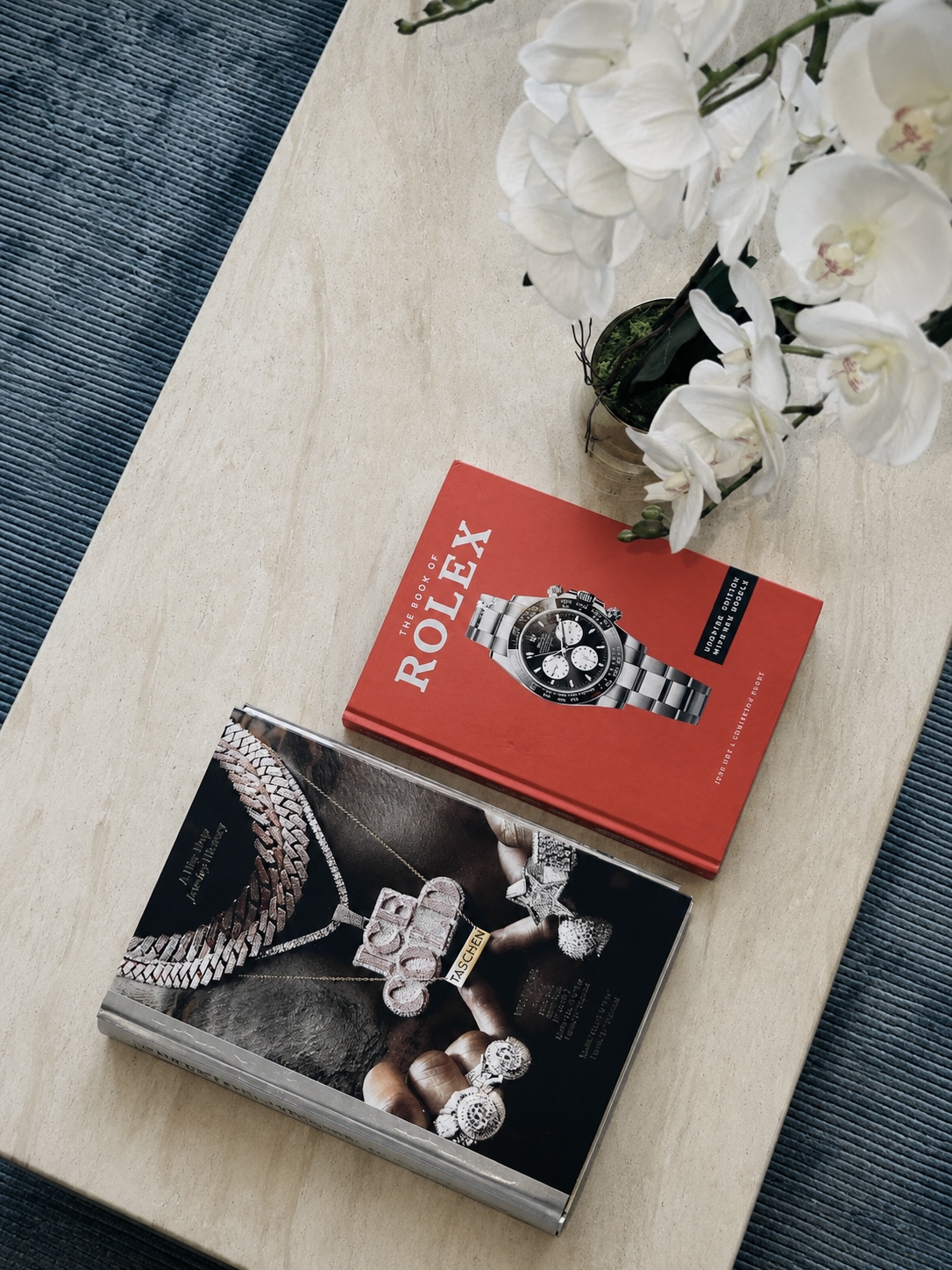 Coffee table styled with Rolex and Ice Cold books and white orchids