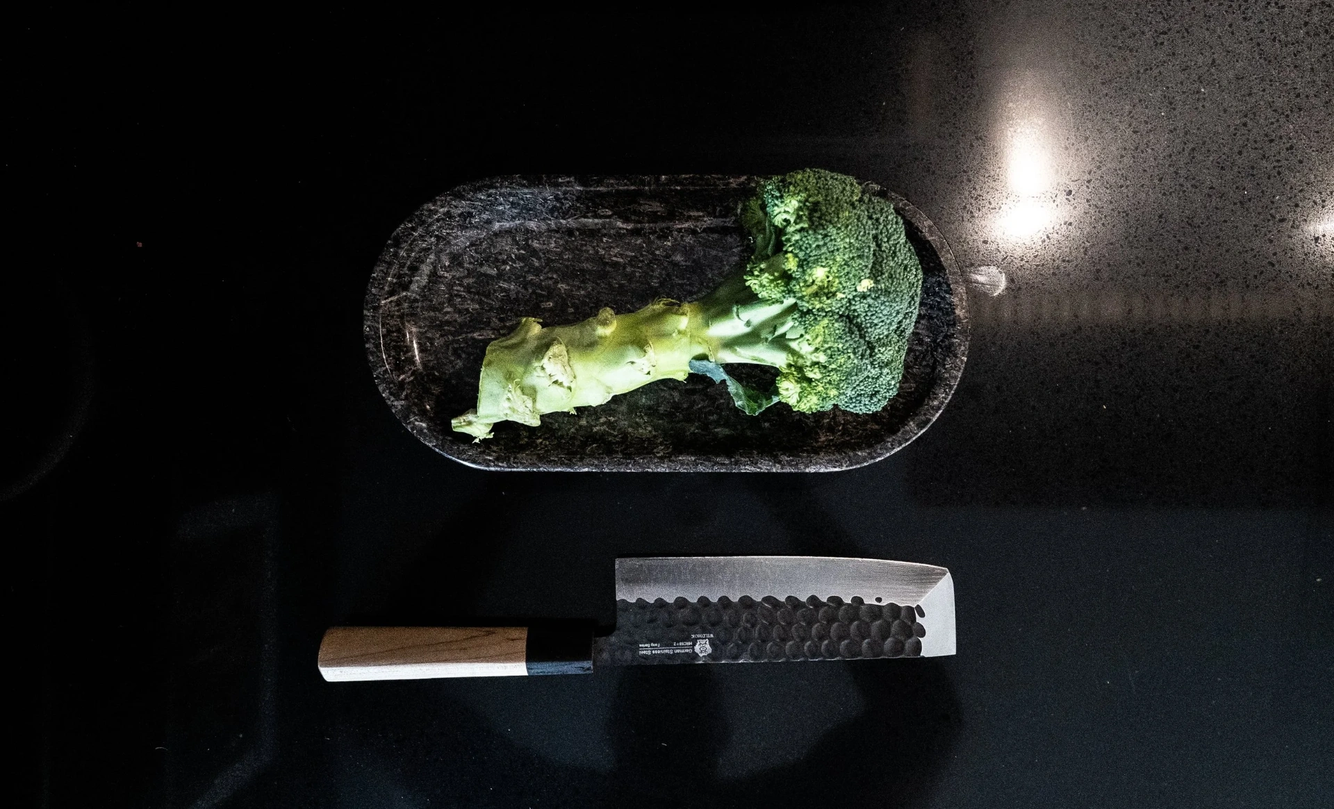 Japanese knife and fresh broccoli on the kitchen counter