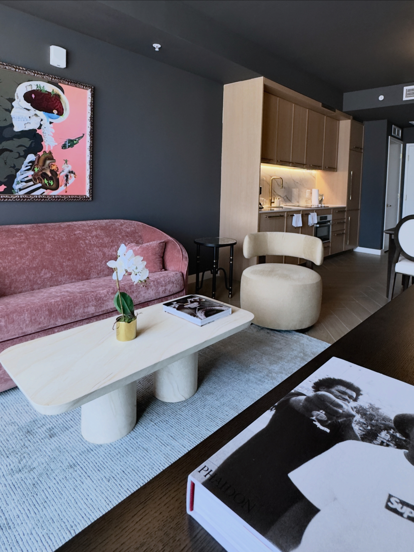 Open living area with pink velvet sofa opening to the kitchen