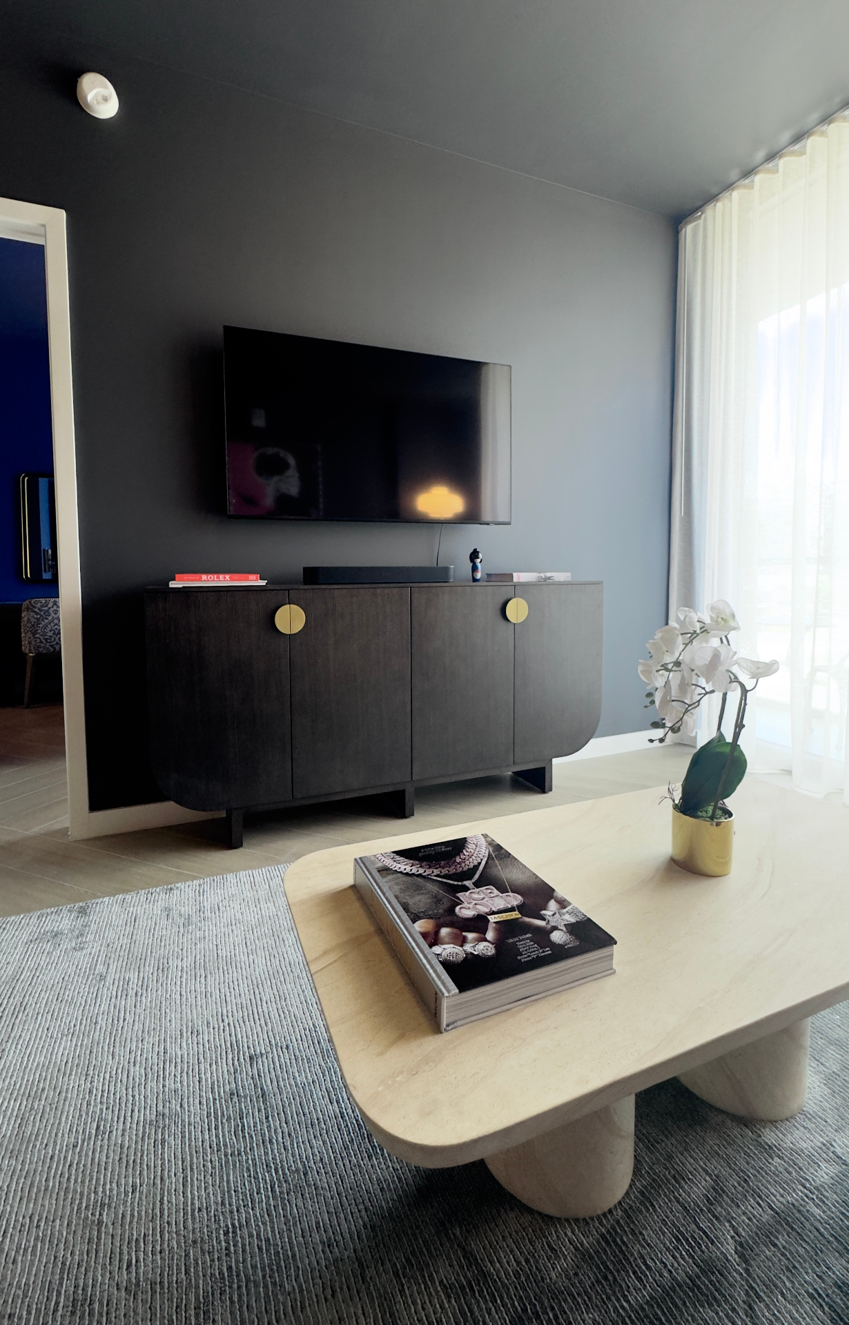 Living room credenza with mounted TV and curated coffee table books
